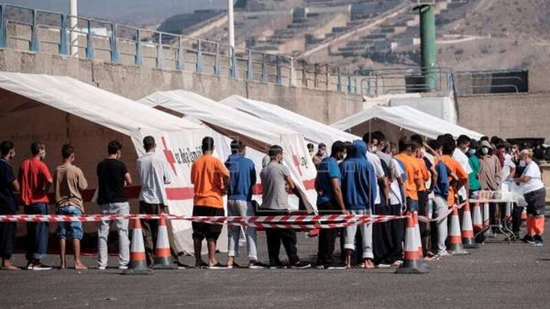 Imagen de archivo de los ocupantes de una patera recibiendo asistencia humanitaria en Arguineguín ( Foto EFE / Ángel Medina G.)